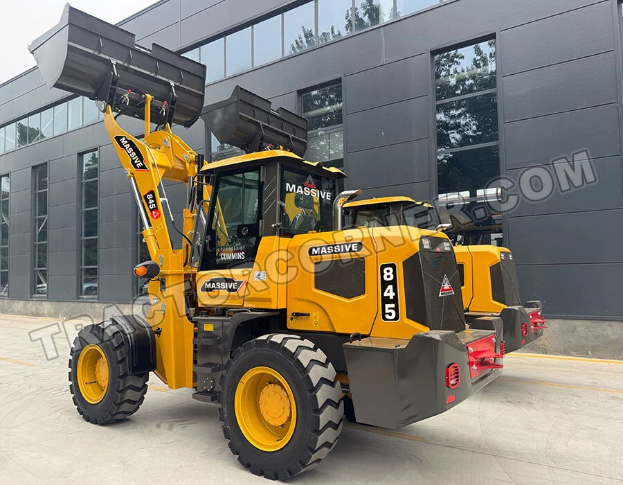 Wheel loader in bright yellow with a large raised front bucket, parked outside a dark office building.